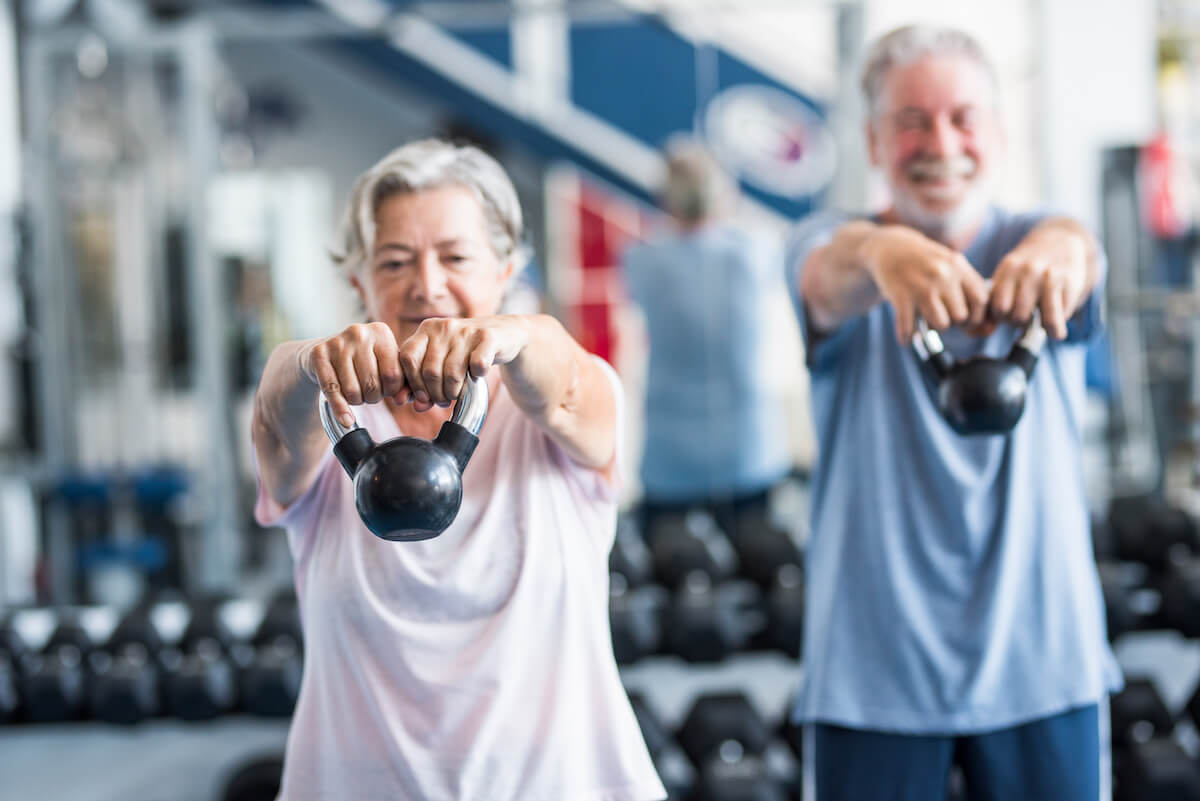 Personas de edad haciendo ejercicio con pesas